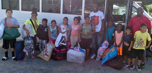 A group of children posing in front of a bus