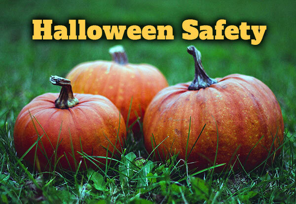 Three pumpkins on the grass with the text, Halloween Safety.