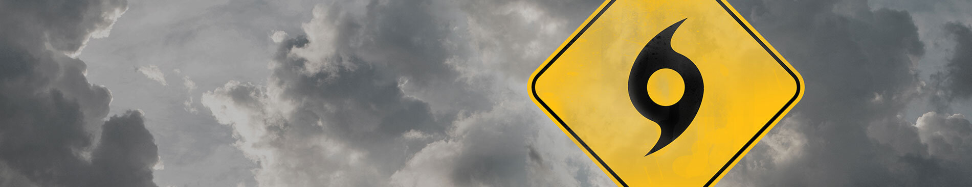A hurricane season sign with the ocean and dark clouds in the background.
