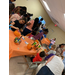 Groups of people painting pumpkins and enjoying the fall festival.