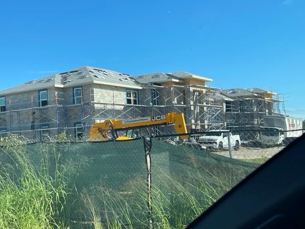 Building surrounded by scaffolding and midway through roofing.