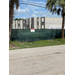 Construction site with tall shells of buildings shown between two trees.