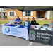 Three women sitting at a Senior Friendship Centers and Big Brothers Big Sisters of the Sun Coast booth.