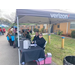 Verizon representatives sitting under a tent at a tradeshow table. 