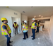 (yellow hard hat) Board Chair Luis Velasco, (in doorway) Board Member Marvella Hearns, (red hard hat) Marmer Construction site foreman Trey Felder, white hard hat - back of Executive Director Becky-Sue Mercer, Board Member Mel Jackson, and NOLLID AHA Asset Risk Manager Frank Dillon.