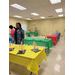Kids paint at tables.