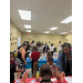 A wide view of a room full of kids painting.