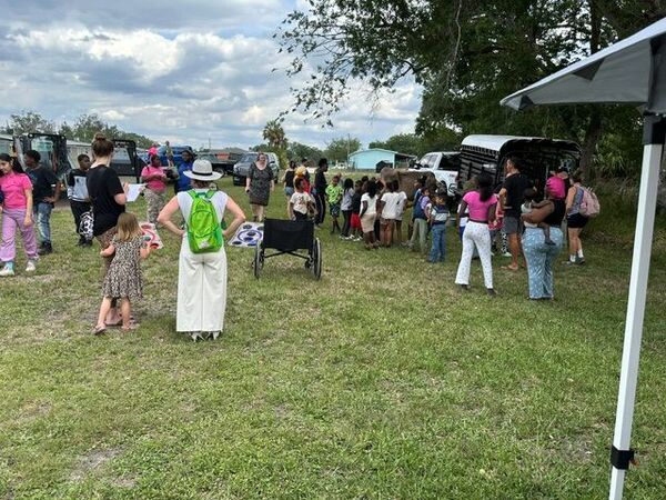 People standing around petting animals. 