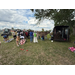  People standing by a cow tied to a trailer. 