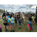  Group of people standing by a cow. 