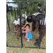  A woman and a young kid standing by a baby cow. 