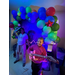  A kid playing on a blowup guitar, in front of a balloon arch. 