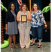  Becky-Sue showing an award with two women standing on either side of her. 