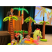  A man speaking at a podium on stage with palm tree inflatables around it. 