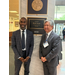  Travaris McCurdy and Kris Cruzada standing next to a plaque for Senator Rick Scott. 
